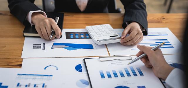 Two People at Desk With Financial Papers